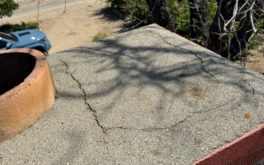 Rooftop view of a chimney crown during an inspection